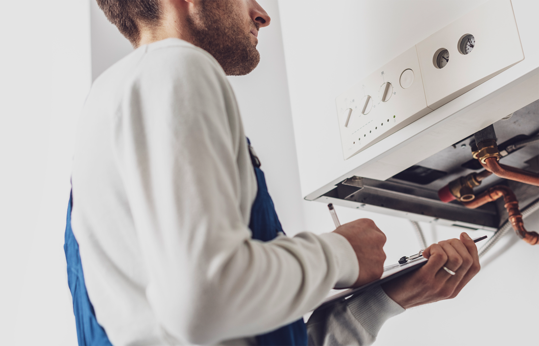 contractor looking at boiler with notepad