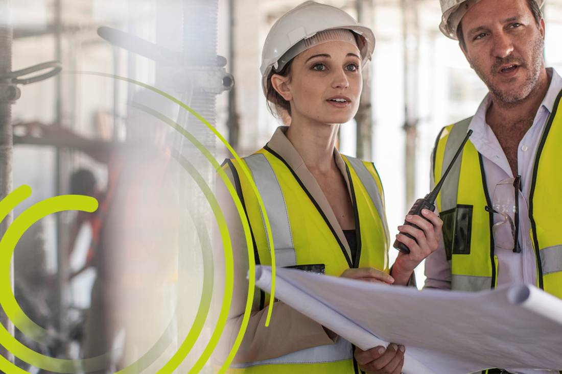 two workers in hi-vis vests in a factory